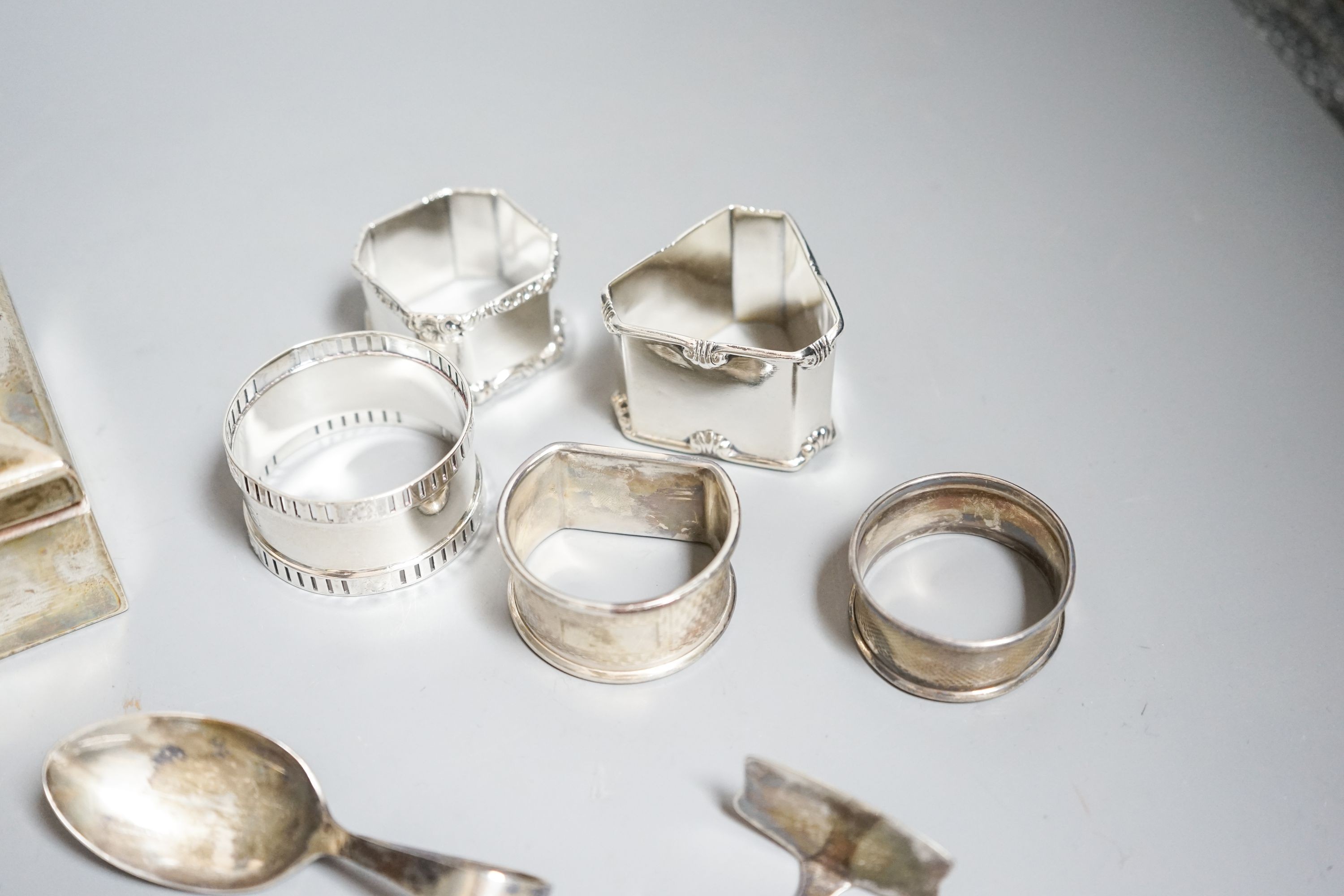 Small silver including a German 800 mounted cigarette box, five napkin rings, spoons etc.